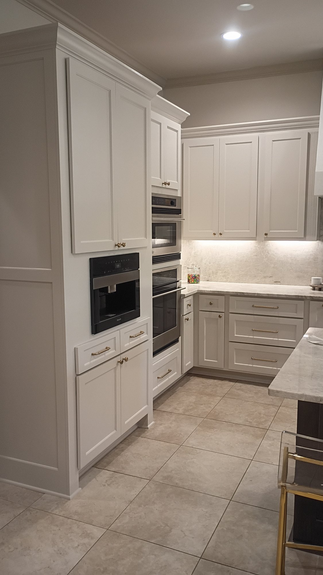 Refinished corner cabinetry with brass hardware