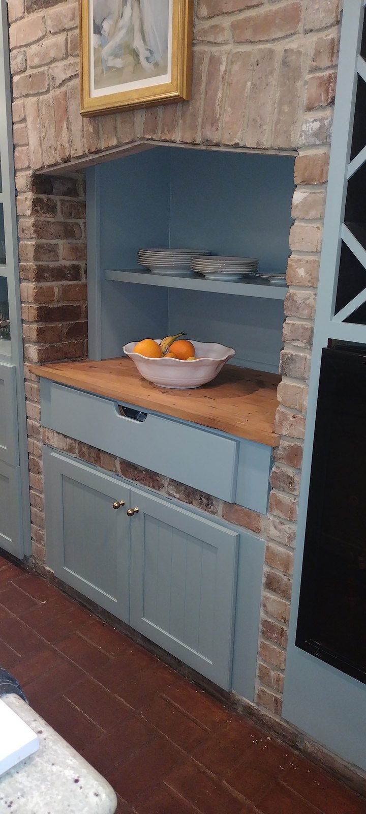 Refinished built-in cabinetry nook framed by exposed brick