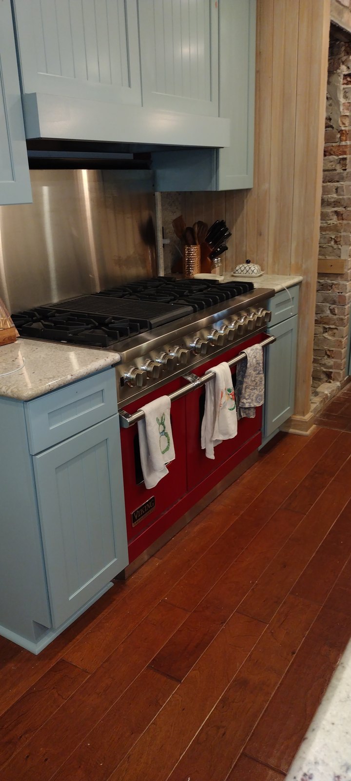 Refinished blue island cabinetry alongside a red range