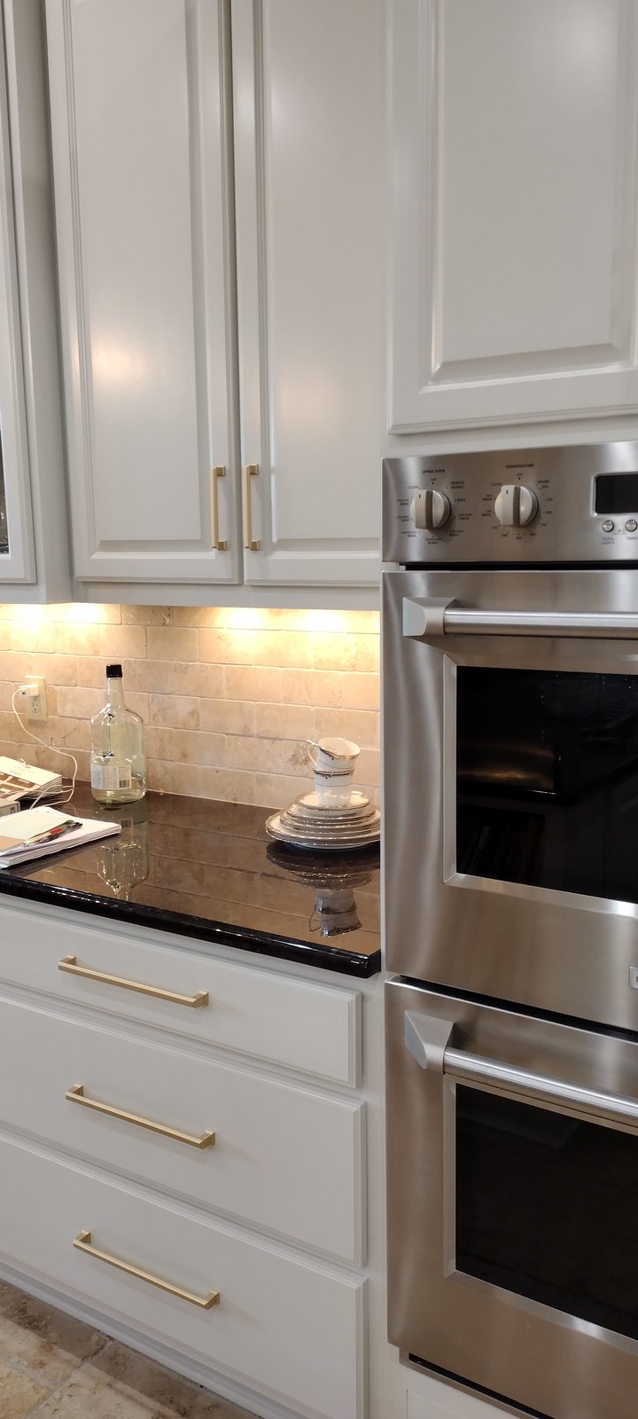 Cream refinished cabinetry surrounding stainless double ovens