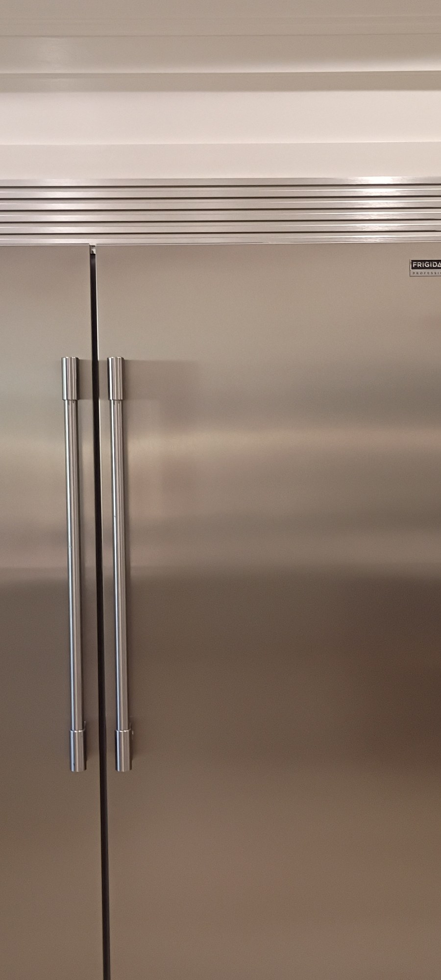 Custom cabinetry panel surround built around the refrigerator